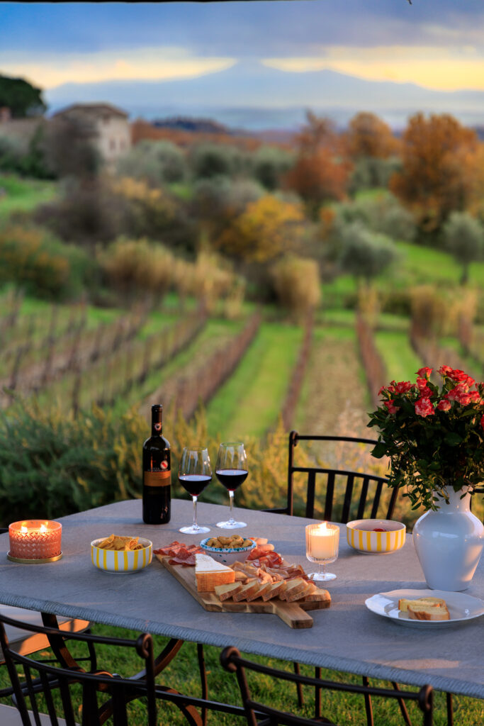 Romantic table set for a private wine and cheese tasting in a Chianti vineyard at sunset