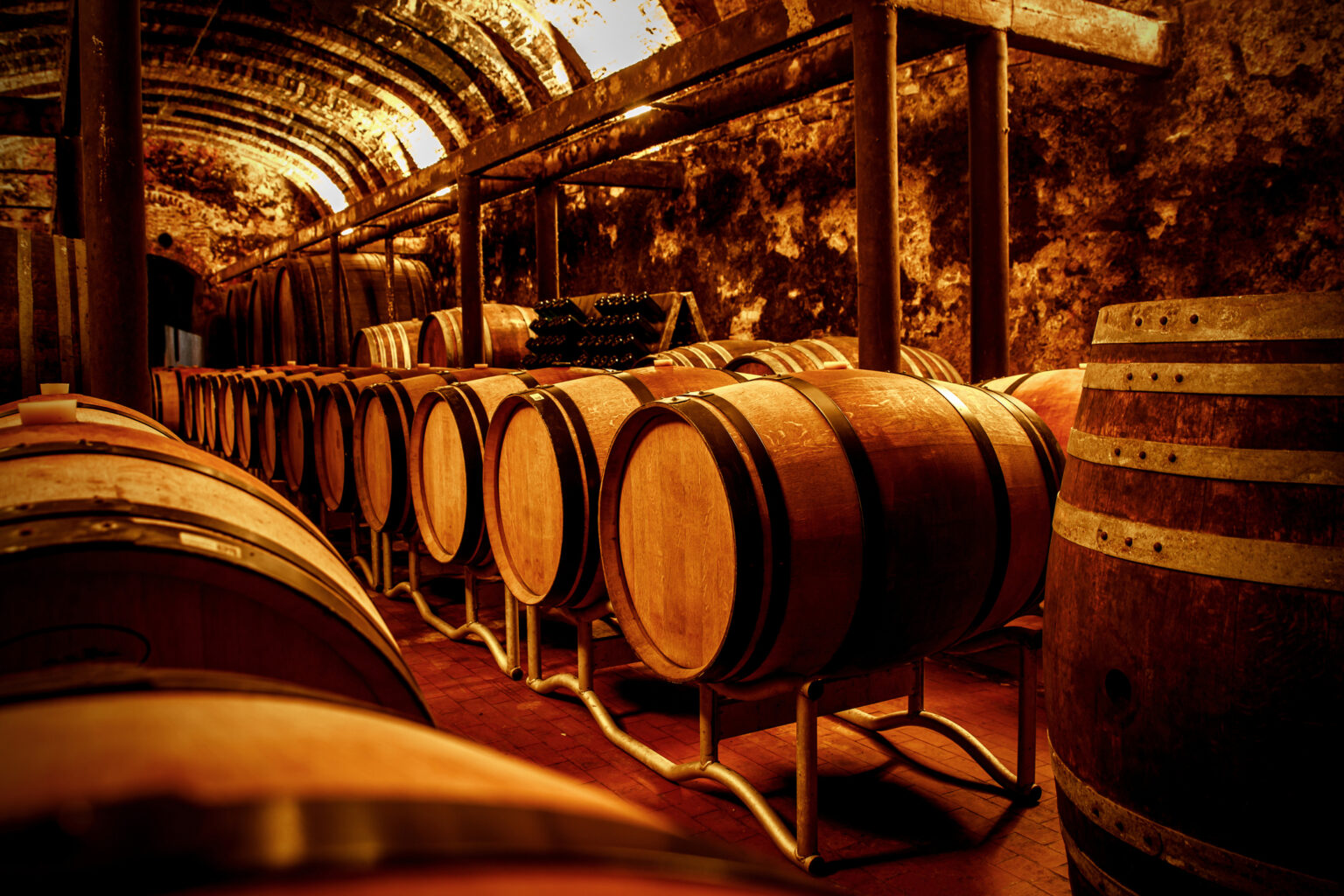 Aged wine barrels in a historic Chianti estate cellar during a private wine tasting tour in Tuscany, Italy