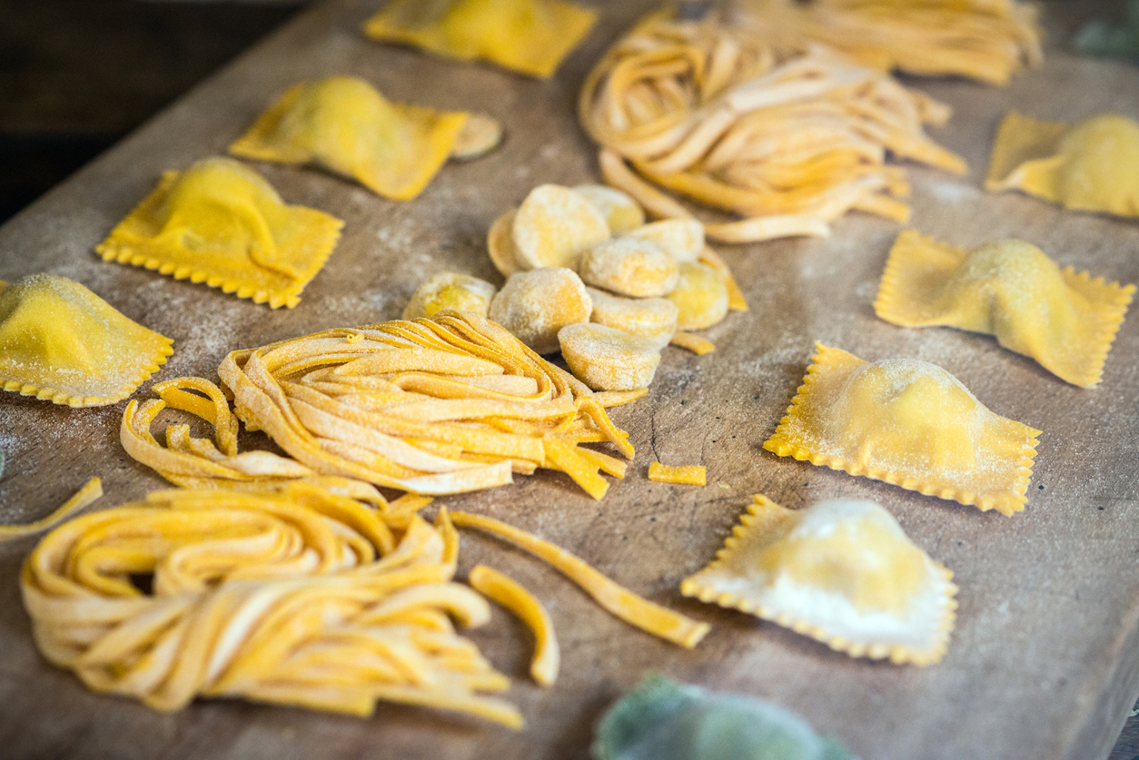 Assorted fresh handmade pasta types including ravioli, tagliatelle, and orecchiette prepared during a cooking class in Rome
